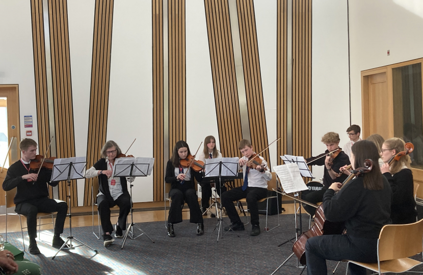 left-to-right) Michael Hoole (Violinist), Pauline Hickman (Instructor-Violin), Isabella Gold (Violinist), Ivy Briggs (Pianist), Brodie Wallace (Violinist), Thomas Bull (Violinist), Ben Gentil (Drummer), Lois Thomson (Violinist), Freya Harley (Celloist) and Hannah Swinney (Celloist) playing at Craig Hoy MSP’s Community Champions reception in the Scottish Parliament. 