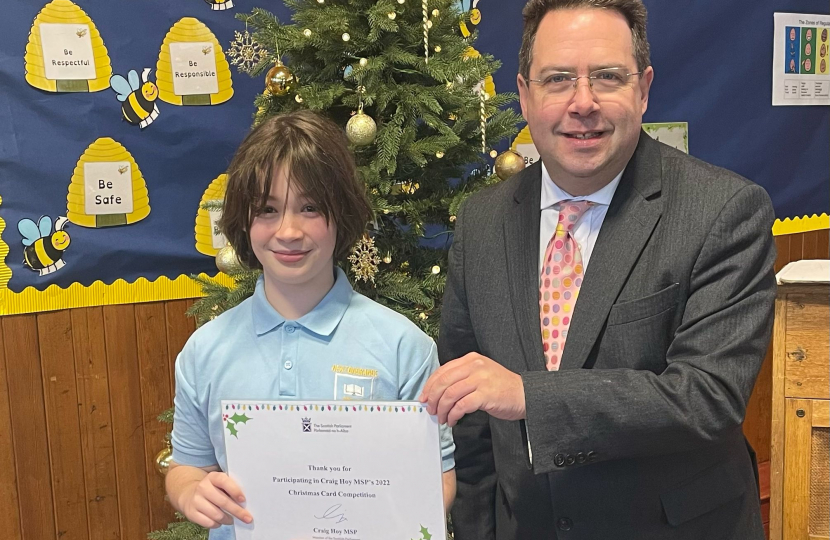 Craig Hoy MSP presenting prize to Delphi Morrison, a Primary 6 from Newtongrange Primary School for his 2022 Christmas Card Competition