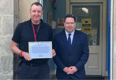 Craig Hoy MSP presenting PC Colin Boyd with framed motion