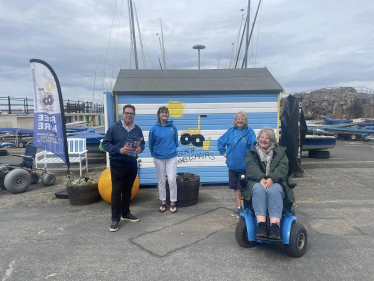 (left-to-right) Craig Hoy MSP with Bryony Capaldi, Lorna Ferry and Carol Murray; using the X8 powered chair