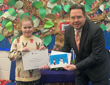 Craig Hoy MSP presenting prize to Rachael Davidson, a Primary 4 from St Andrews RC Primary School for his 2022 Christmas Card Competition